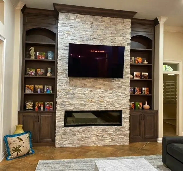 Custom built-in bookcases flanking a stone fireplace