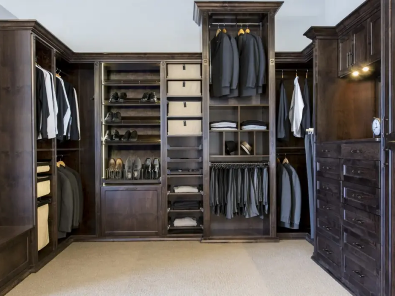 All-wood men&rsquo;s walk-in closet with dark custom cabinetry
