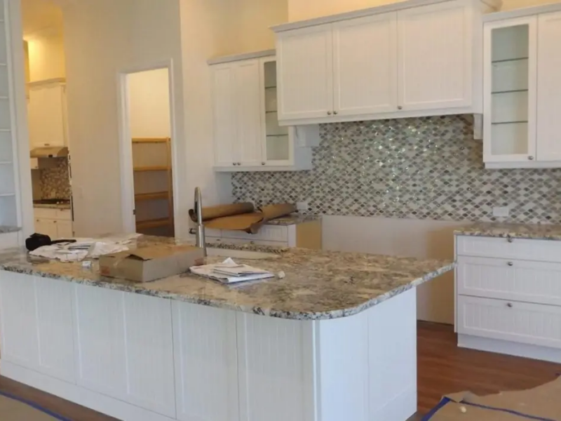 White kitchen cabinets and island during installation