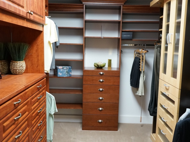 Walk-in closet with cherry-finish drawers, shelving, and hanging space