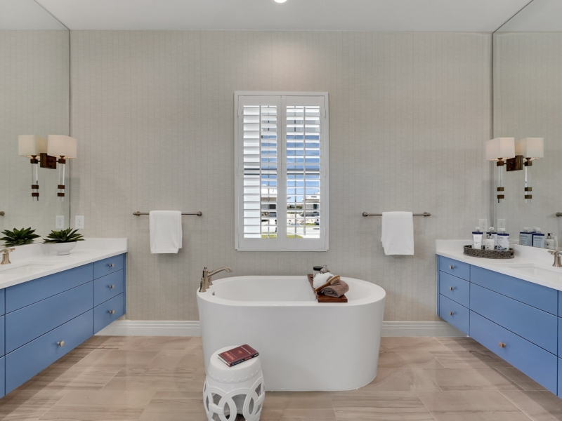 Contemporary bathroom with blue custom double vanities and a freestanding tub