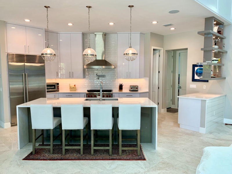 Contemporary kitchen with white gloss cabinets, a stainless range hood, and island seating