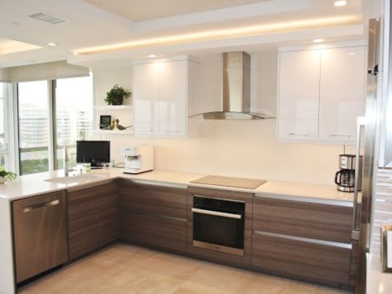 Contemporary L-shaped kitchen with wood-grain base cabinets and a stainless hood