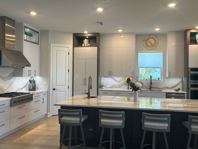 Contemporary kitchen with white flat-panel cabinets and a navy island with seating