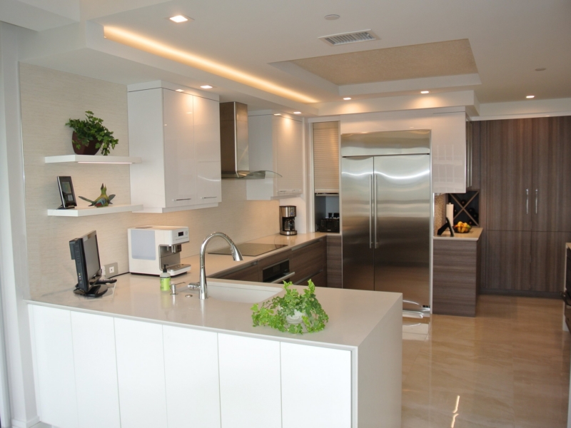 Contemporary kitchen with white gloss cabinets, a peninsula, and floating shelves