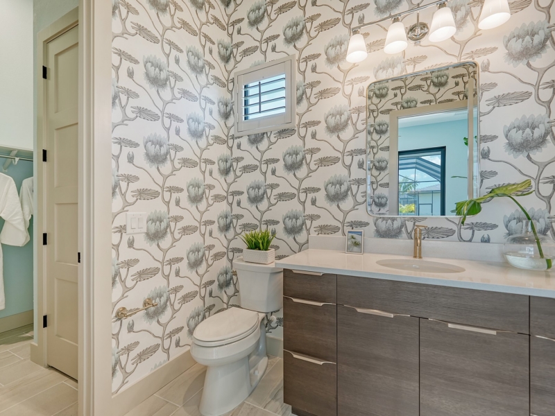 Contemporary powder room with a wood-grain floating vanity and botanical wallpaper
