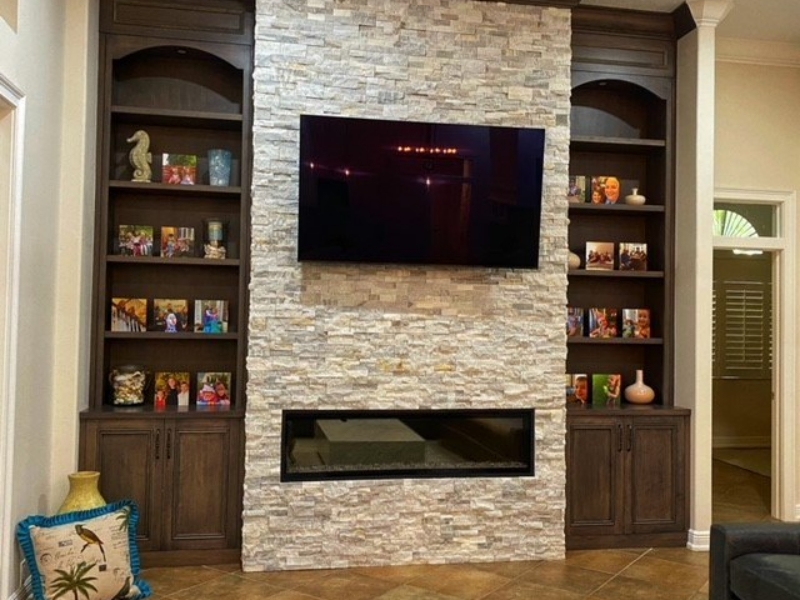 Custom built-in bookcases flanking a stone fireplace