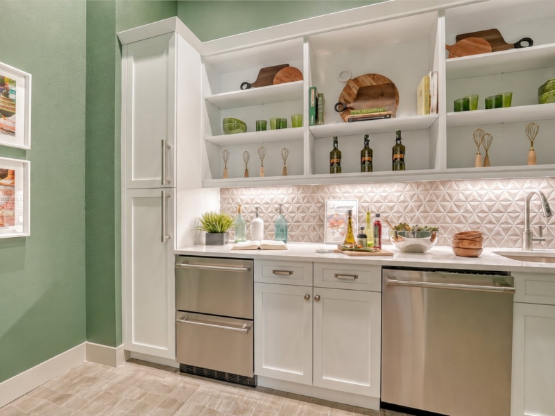 Kitchenette with white custom cabinets, open shelving, and beverage drawers