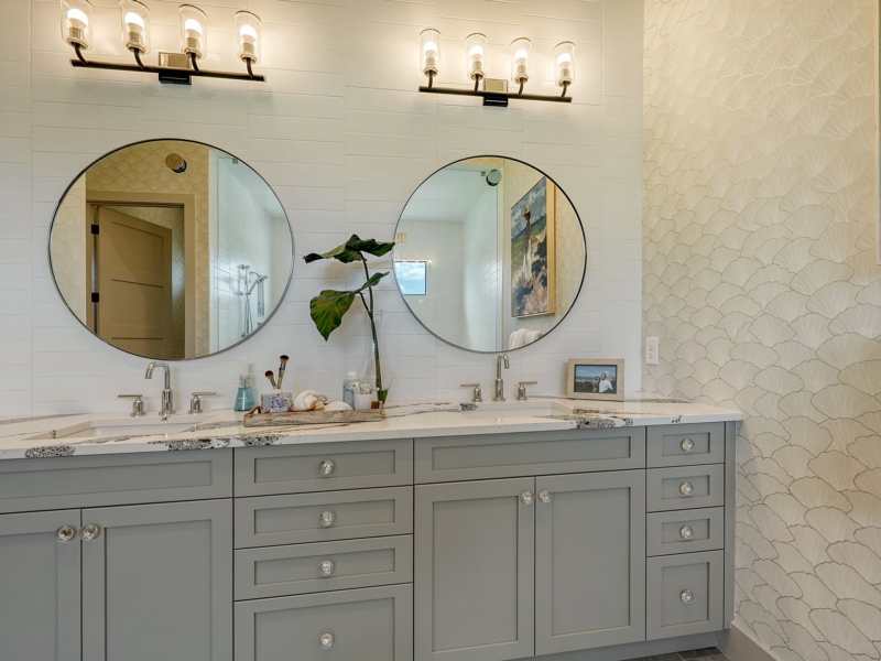 Transitional bathroom with a gray double vanity and round mirrors