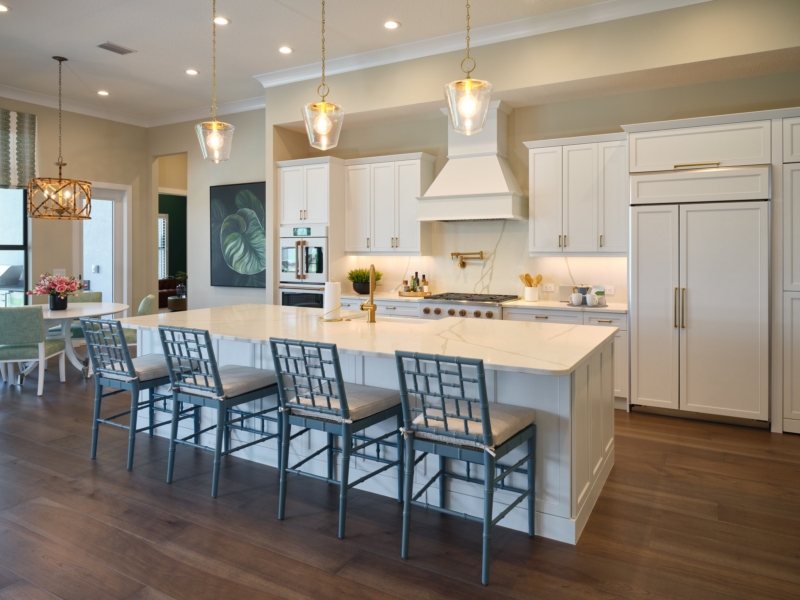 Transitional kitchen with white cabinets, a custom hood, and island seating