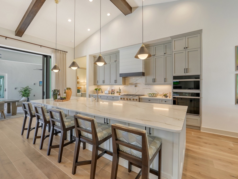 Transitional kitchen with gray cabinets and a long island under a beamed ceiling