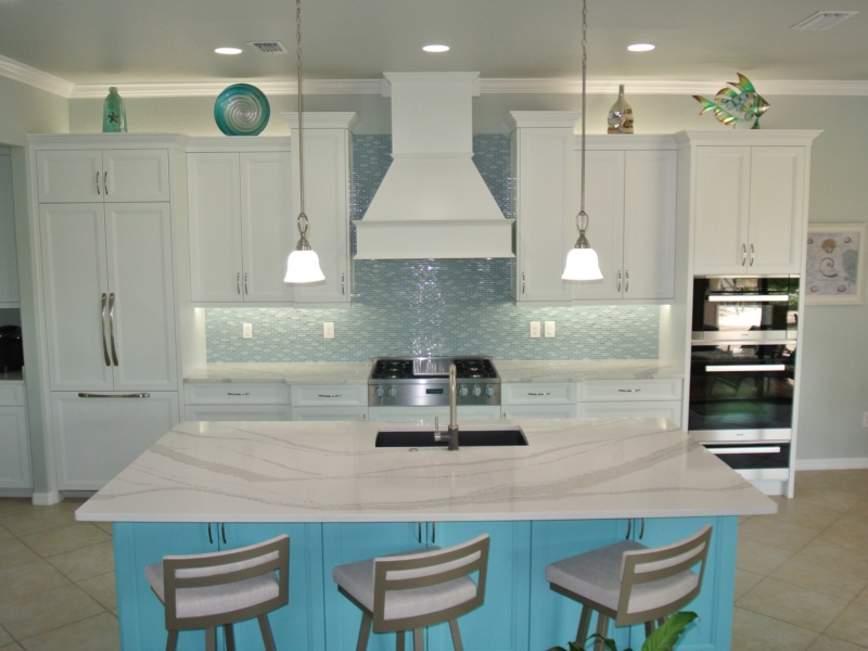 Transitional kitchen with white cabinets, a turquoise island, and a custom range hood