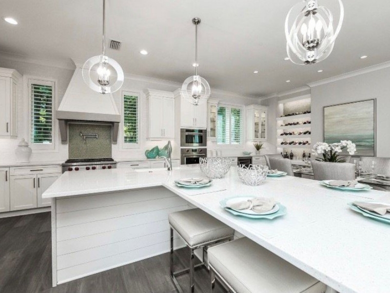White transitional kitchen with a large island and custom range hood