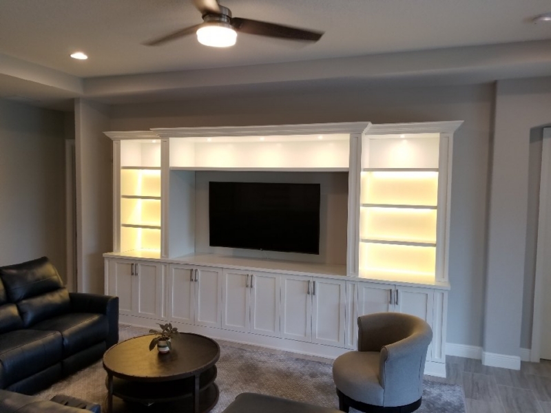 White built-in media wall with lighted display shelves