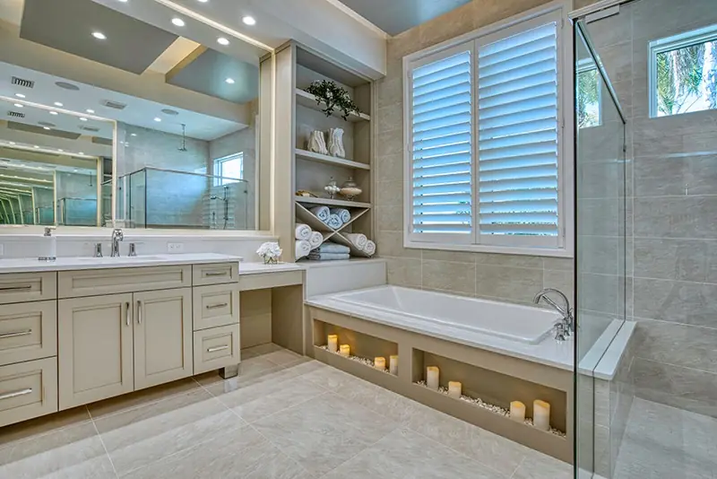 Transitional bathroom with custom vanity cabinets, open shelving, and a soaking tub