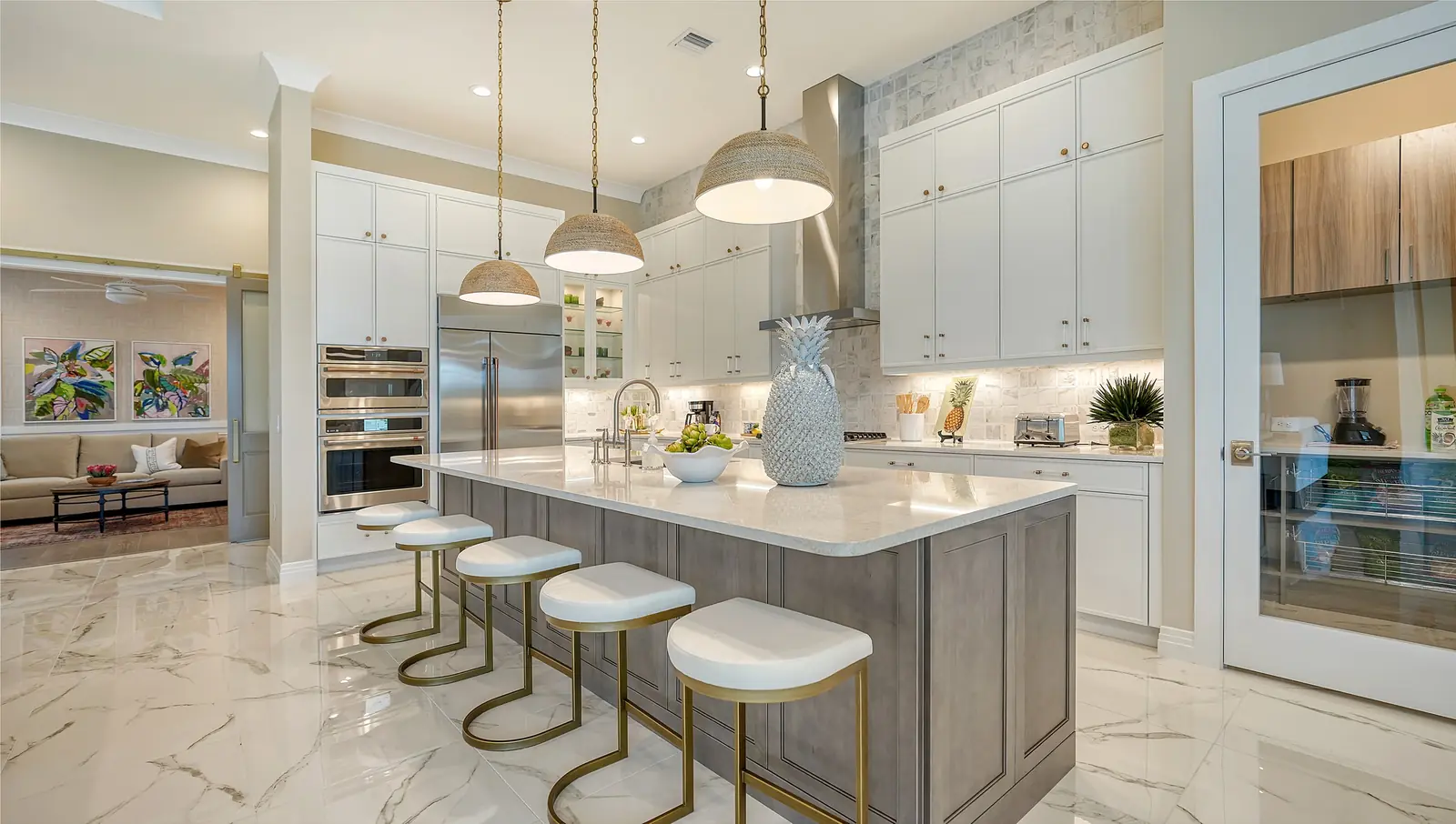 Transitional kitchen with white custom cabinets, a gray island, and pendant lights in Florida