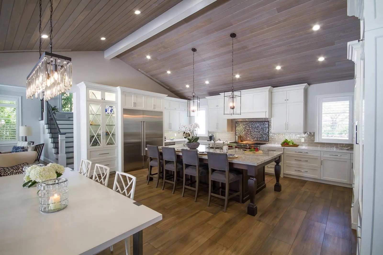 Transitional kitchen with white custom cabinets under a vaulted wood ceiling in Florida
