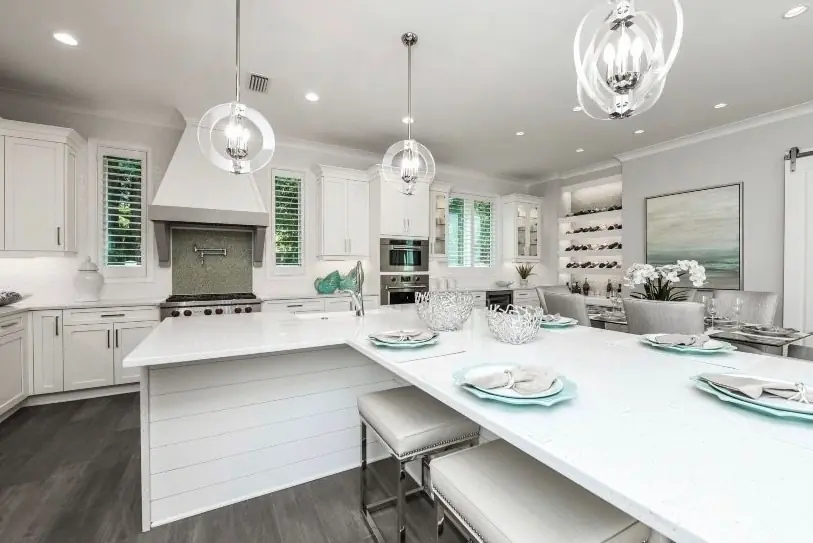 White transitional kitchen with a large island and custom range hood